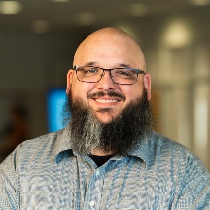 Michael Perrenoud, founder of Steepley, smiling in glasses and a blue check shirt.